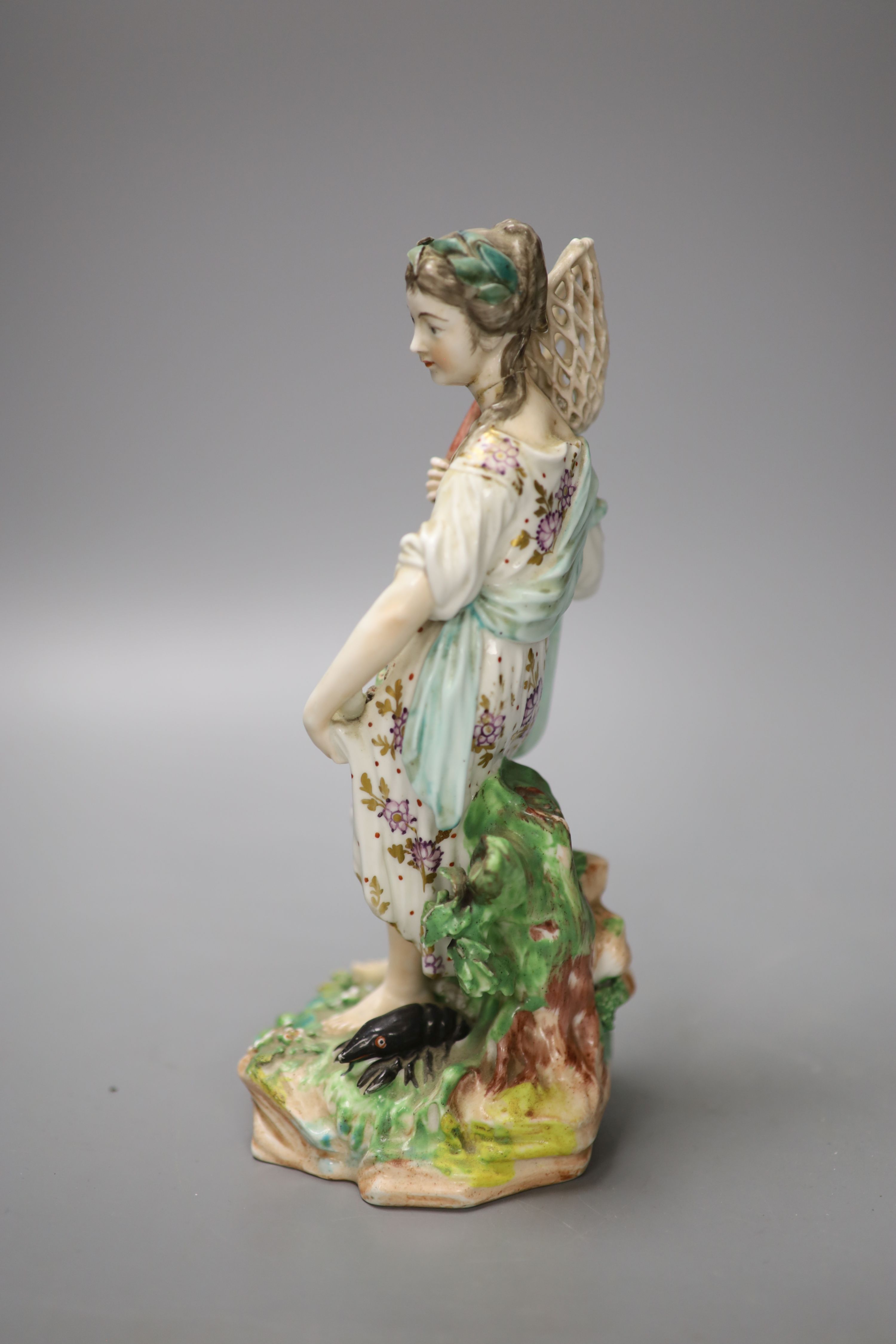 A Derby figure of Water, modelled as a girl holding a fish net her apron holding three fish, stand on a naturalistic beside a black lob